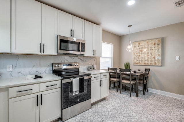 kitchen with appliances with stainless steel finishes, decorative light fixtures, decorative backsplash, and white cabinets