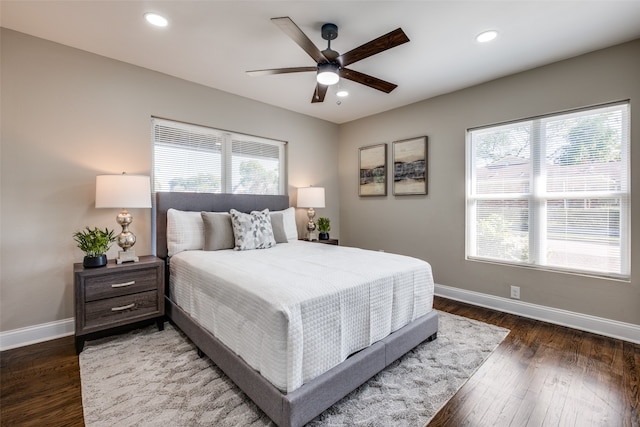 bedroom featuring multiple windows, dark wood-type flooring, and ceiling fan