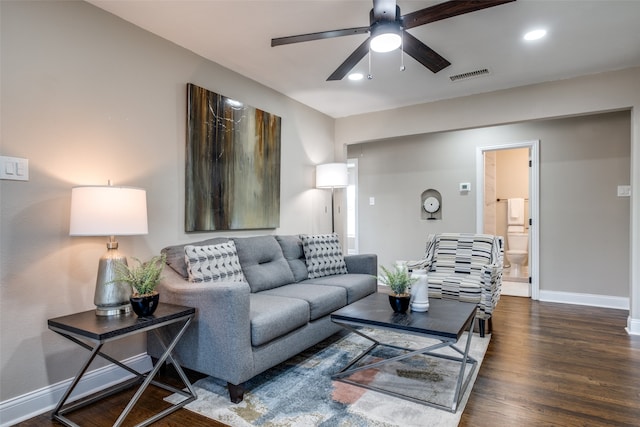 living room featuring ceiling fan and dark hardwood / wood-style flooring