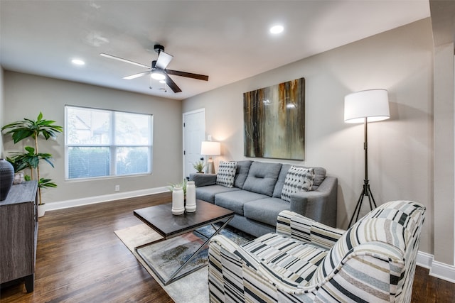 living room featuring dark wood-type flooring and ceiling fan