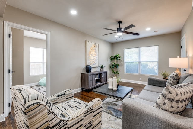 living room featuring ceiling fan and dark hardwood / wood-style flooring