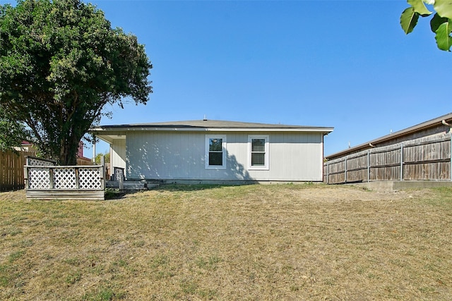 rear view of property featuring a yard