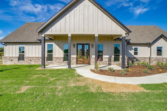 rear view of house featuring covered porch and a lawn