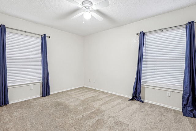 carpeted spare room with ceiling fan and a textured ceiling