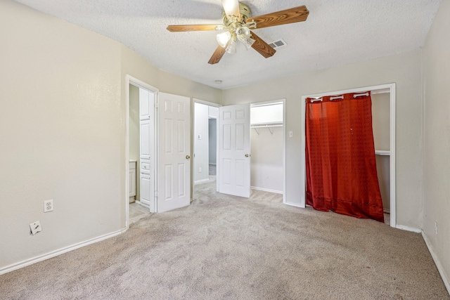 unfurnished bedroom featuring a textured ceiling, light carpet, and ceiling fan