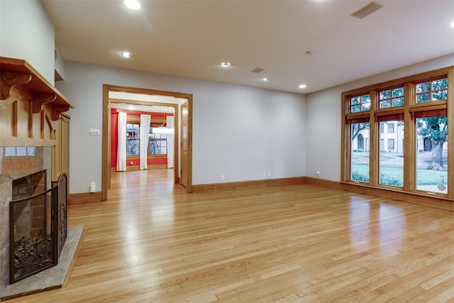 unfurnished living room with light wood-type flooring and a fireplace