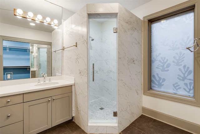 bathroom featuring vanity, a shower with shower door, and tile patterned flooring