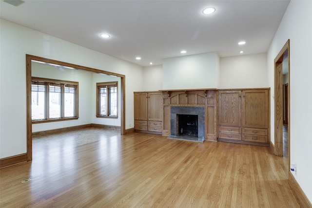 unfurnished living room with a premium fireplace and light hardwood / wood-style flooring