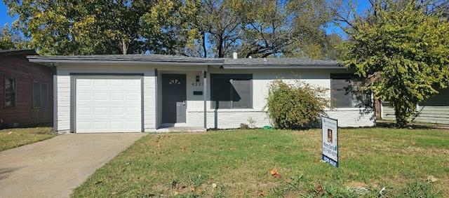 ranch-style home with a garage and a front lawn