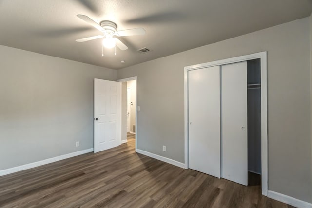 unfurnished bedroom featuring dark hardwood / wood-style floors, ceiling fan, and a closet