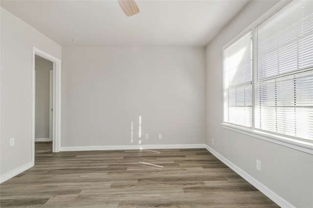 empty room with ceiling fan and dark wood-type flooring