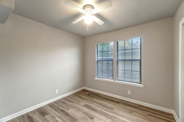 empty room with ceiling fan and light hardwood / wood-style flooring