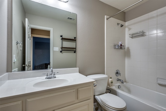 full bathroom featuring tiled shower / bath combo, toilet, and vanity