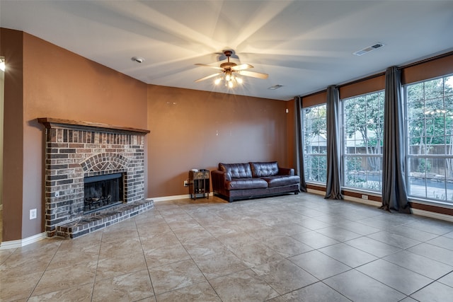 unfurnished living room featuring a fireplace, ceiling fan, and light tile patterned flooring