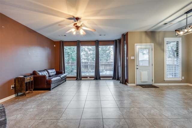 living room featuring ceiling fan, expansive windows, and light tile patterned floors