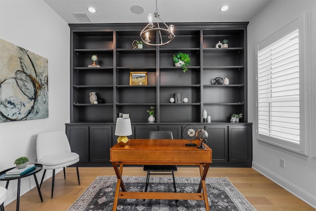 home office featuring a wealth of natural light, a chandelier, and light wood-type flooring