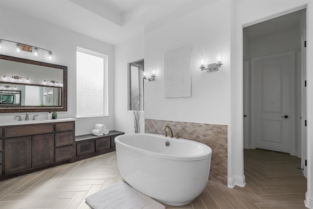 bathroom with vanity, a tub to relax in, and parquet floors