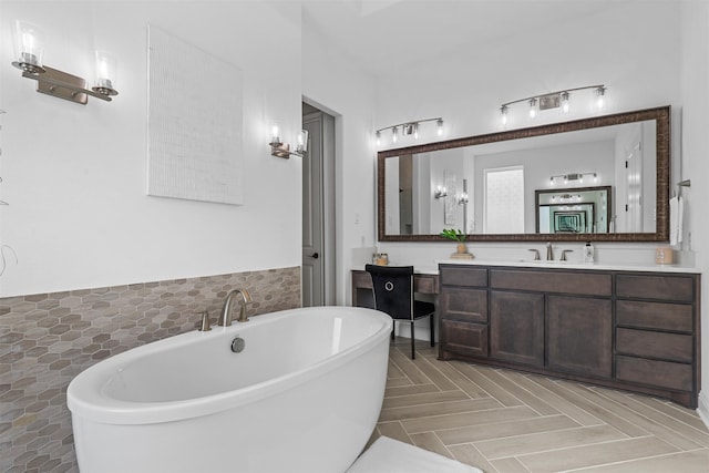 bathroom with vanity, a tub, and parquet flooring