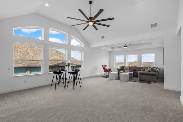 carpeted living room with high vaulted ceiling and ceiling fan