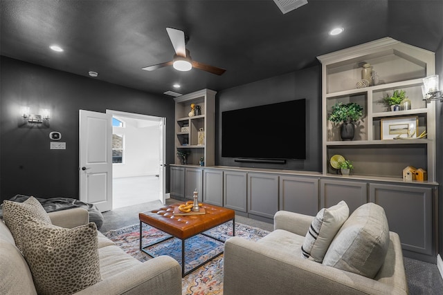 carpeted living room featuring built in shelves and ceiling fan