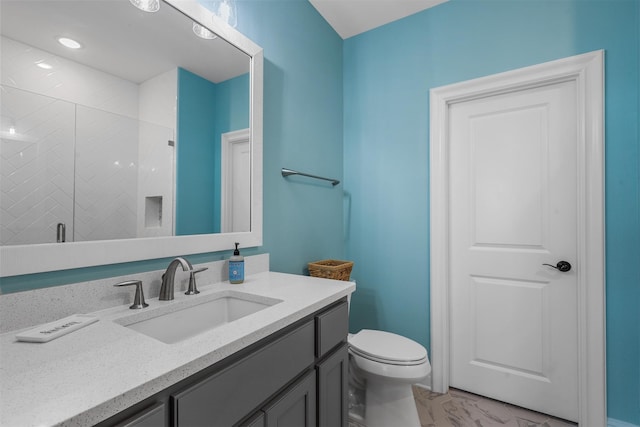 bathroom with a shower with door, toilet, and vanity