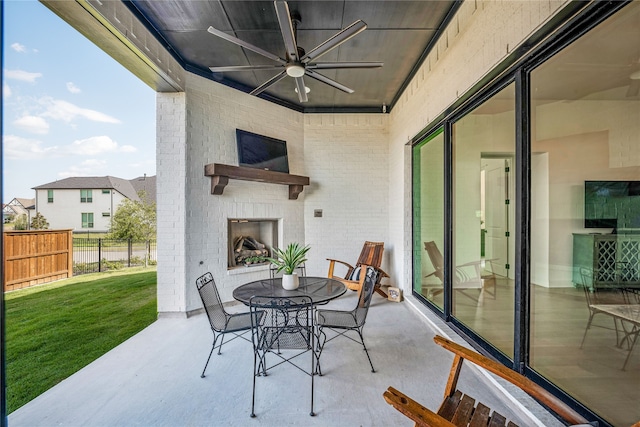 view of patio featuring an outdoor brick fireplace and ceiling fan