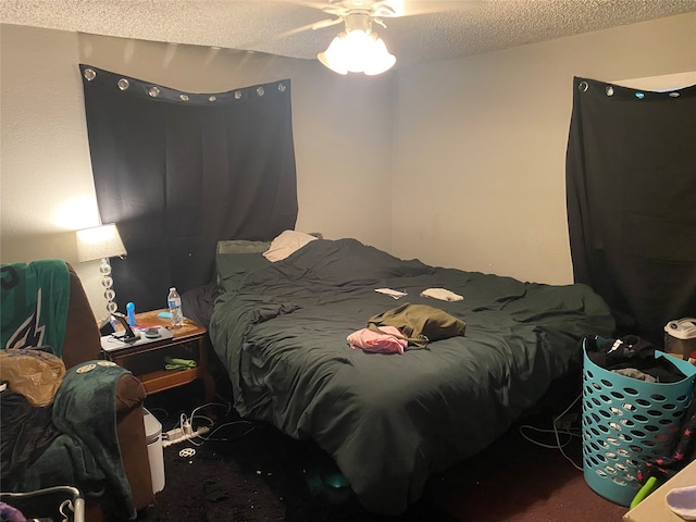 carpeted bedroom featuring ceiling fan and a textured ceiling