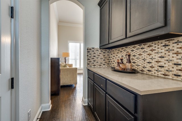 kitchen with decorative backsplash, ornamental molding, and dark wood-type flooring