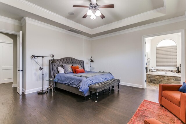 bedroom featuring ceiling fan, a raised ceiling, dark hardwood / wood-style flooring, ensuite bathroom, and ornamental molding