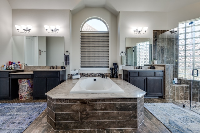 bathroom featuring hardwood / wood-style floors, vanity, separate shower and tub, and lofted ceiling