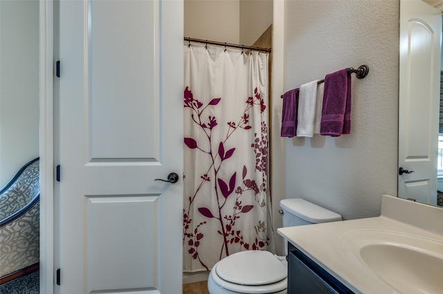 bathroom featuring vanity, a shower with shower curtain, and toilet