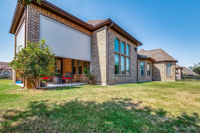 back of house featuring a yard and a patio