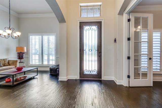 entrance foyer featuring a chandelier, crown molding, and dark wood-type flooring