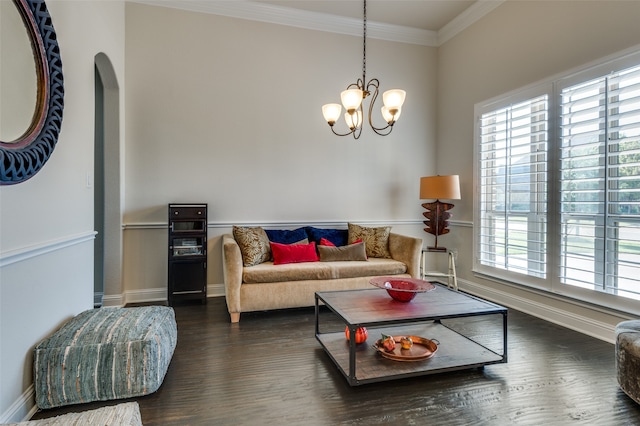 living room with dark hardwood / wood-style flooring, ornamental molding, and a notable chandelier