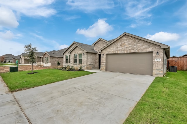 view of front of home with cooling unit, a front lawn, and a garage