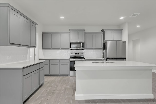 kitchen featuring stainless steel appliances, sink, and gray cabinets