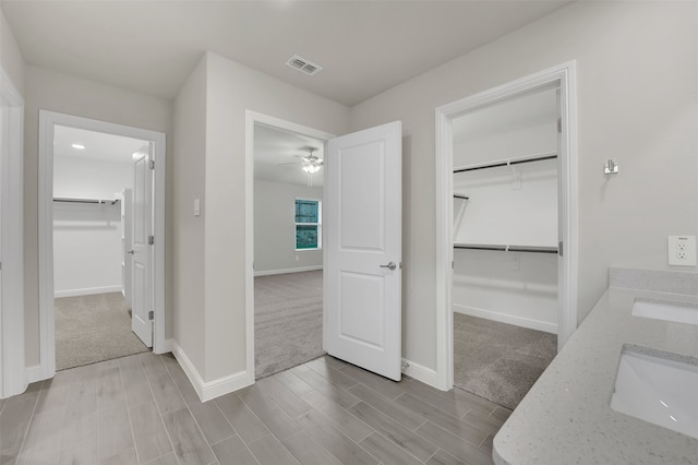 hallway with light carpet and sink