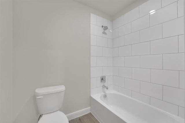 bathroom featuring toilet, hardwood / wood-style floors, and tiled shower / bath combo