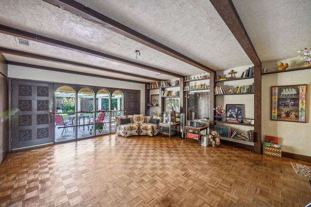 interior space with a textured ceiling and beamed ceiling