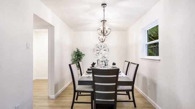 dining area with light hardwood / wood-style flooring and a chandelier