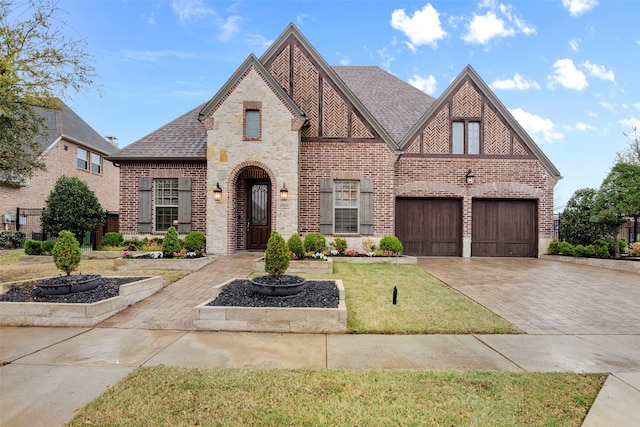 english style home with a front lawn and a garage