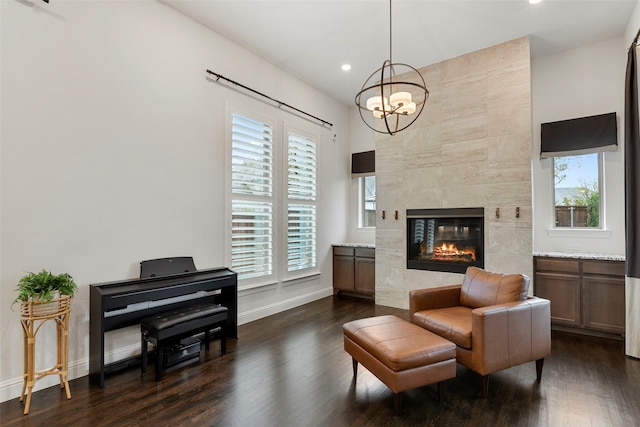 sitting room featuring an inviting chandelier, dark hardwood / wood-style floors, and a fireplace