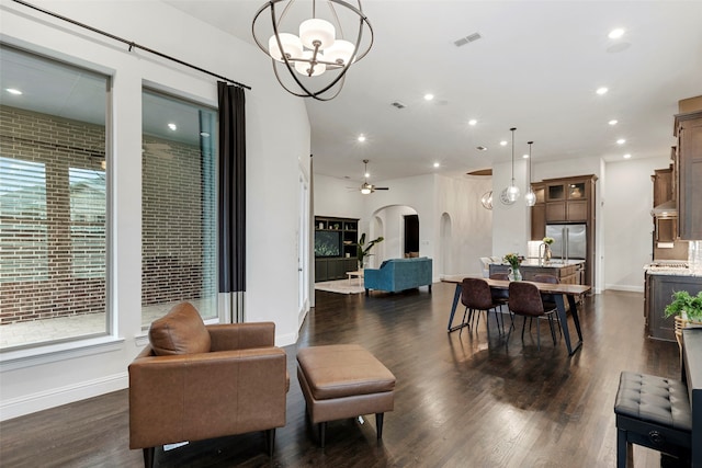 interior space featuring dark wood-type flooring and ceiling fan with notable chandelier