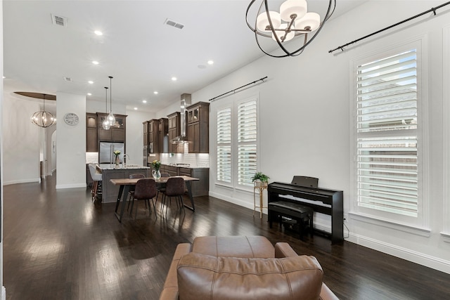 dining room featuring sink, a chandelier, and dark hardwood / wood-style floors