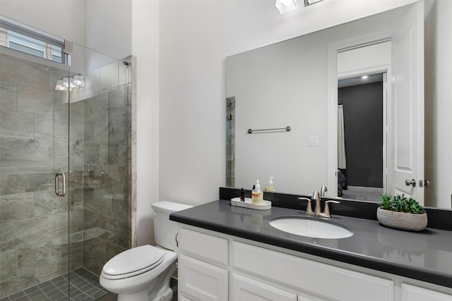 bathroom featuring vanity, toilet, and a shower with shower door