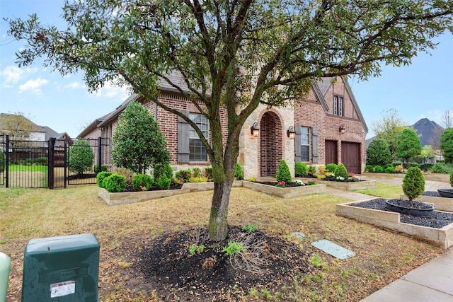 tudor-style house with a front lawn and a garage