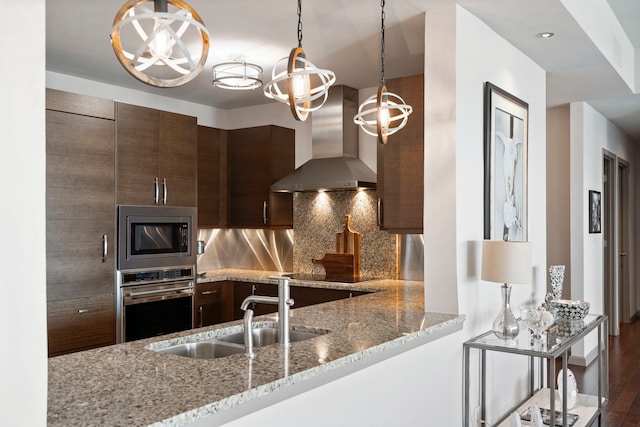 kitchen featuring light stone countertops, exhaust hood, appliances with stainless steel finishes, and dark hardwood / wood-style flooring