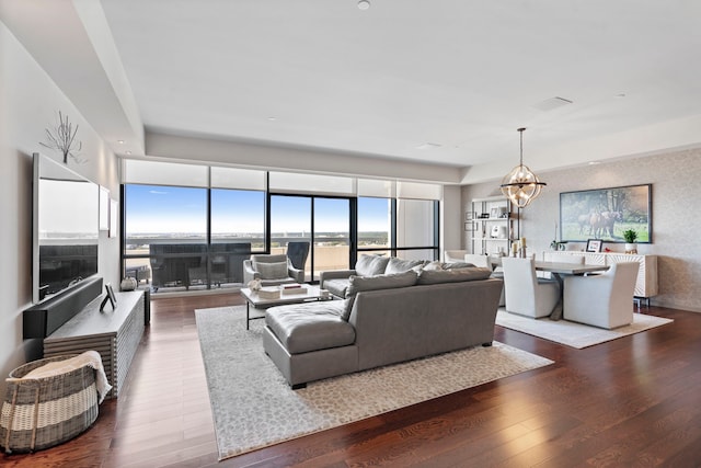 living room with a notable chandelier and dark hardwood / wood-style floors