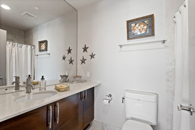 bathroom featuring walk in shower, vanity, toilet, and tile patterned floors