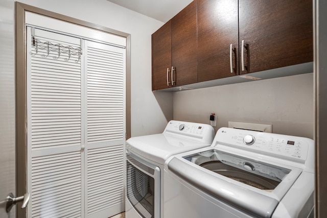 washroom featuring washer and clothes dryer and cabinets